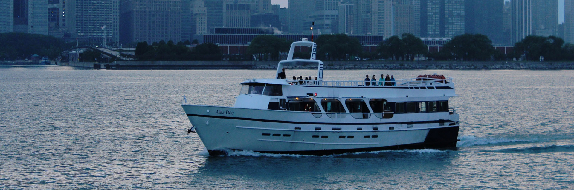 Chicago private yacht charter Anita Dee I on the water at dusk.